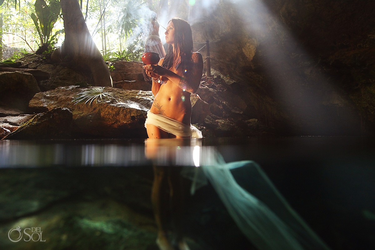 Half Underwater naked bride standing in a smokey cave in mexico