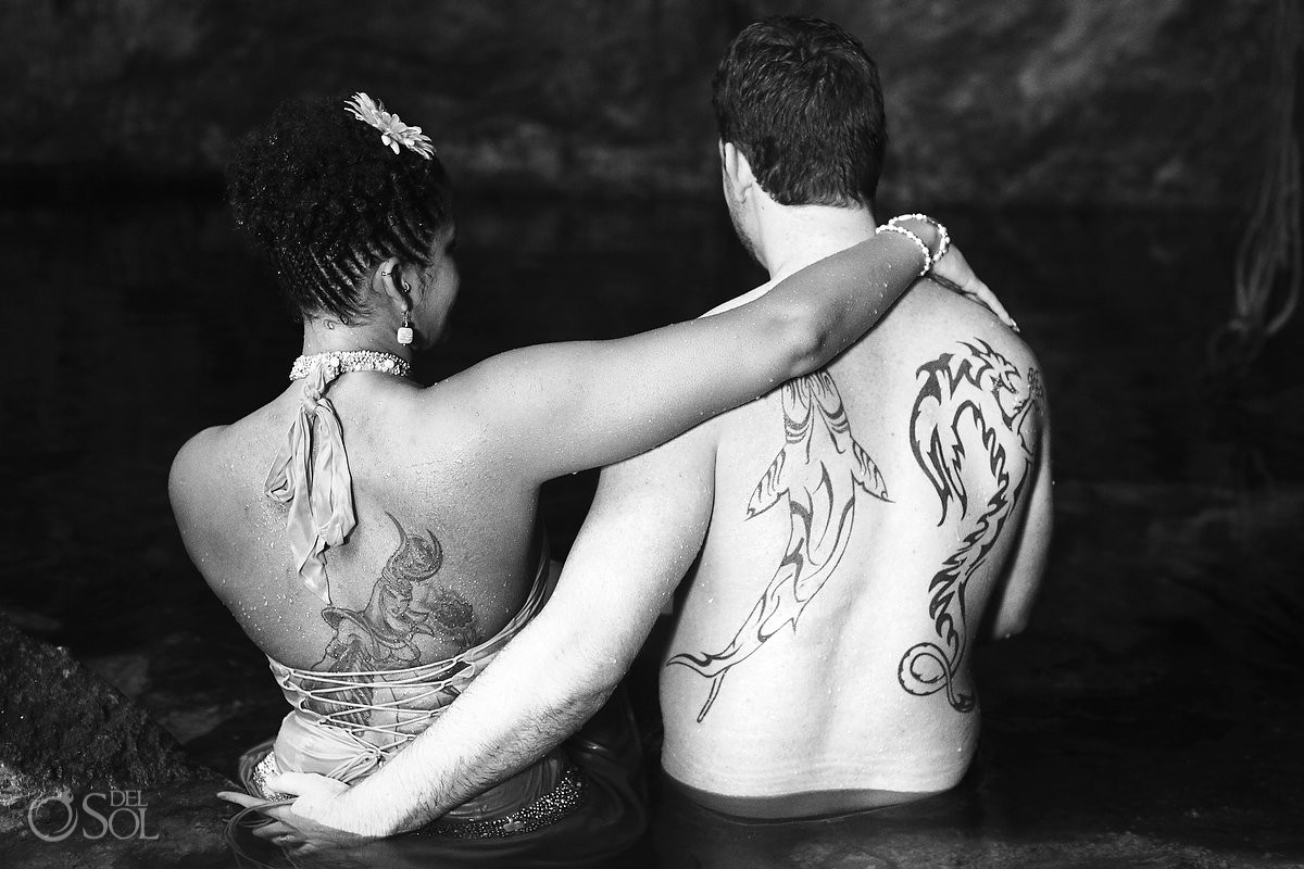 adam and eve session bride and groom tattooed standing in the cenote water