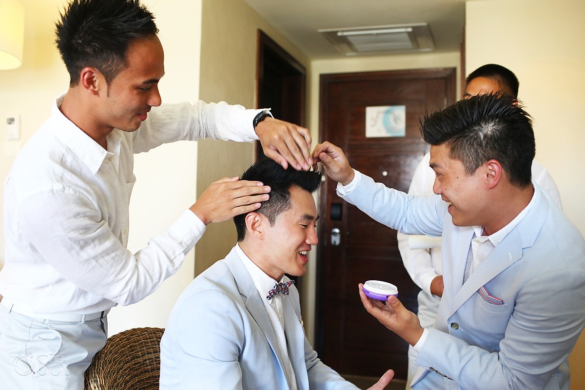 Groom getting ready, styling hair at destination wedding in Mexico