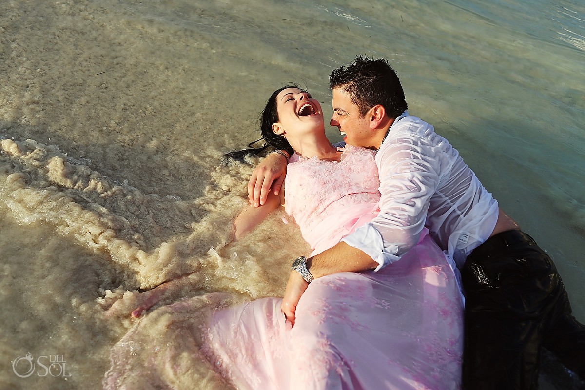 Bride and groom in a beach trash the dress in the water in Mexico