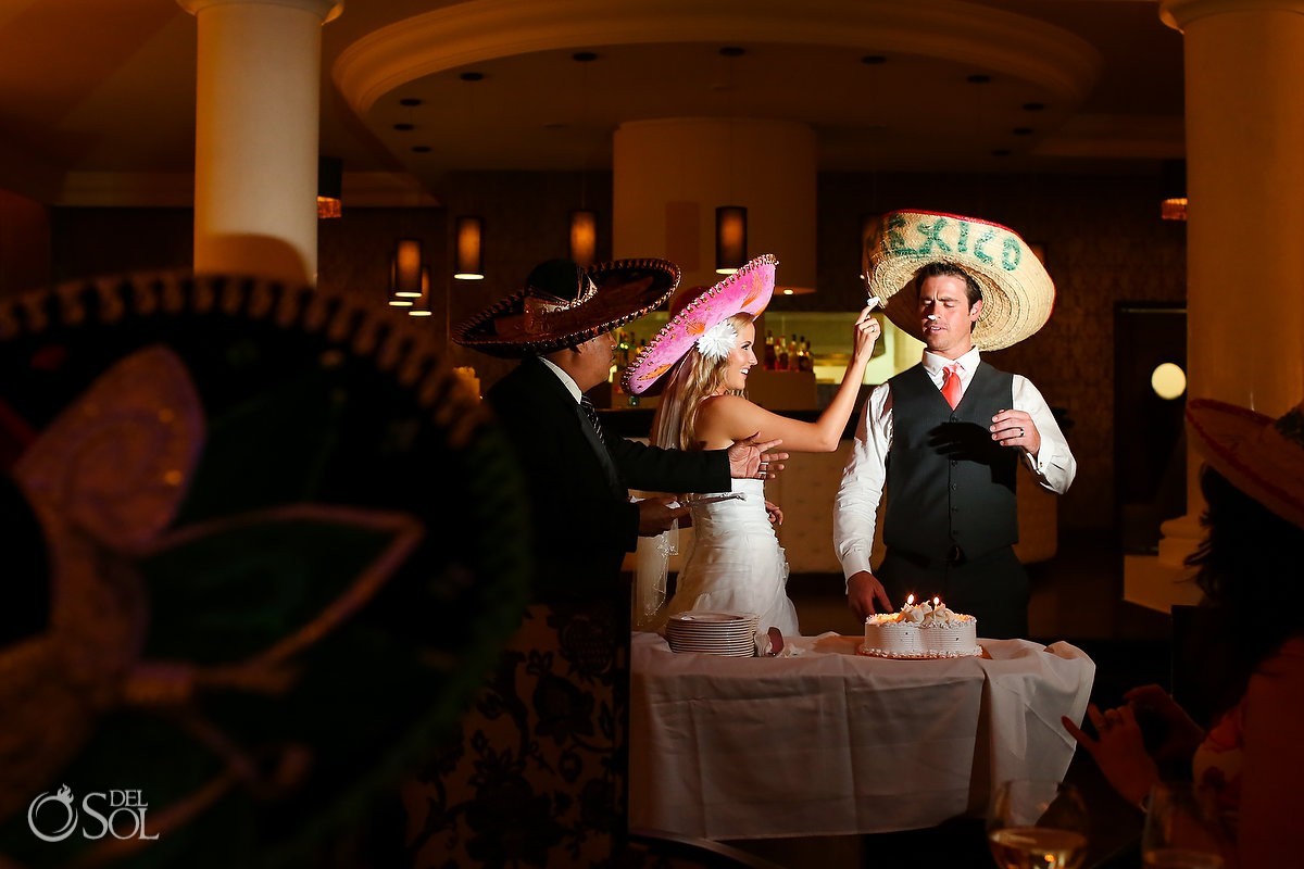 Newlyweds in sombreros cutting the cakes