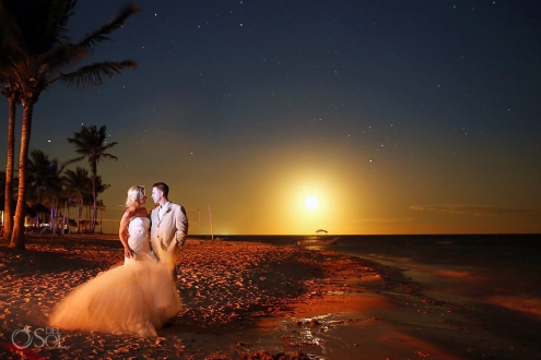 Bride and groom on the beach under moonlight at dreams tulum hotel