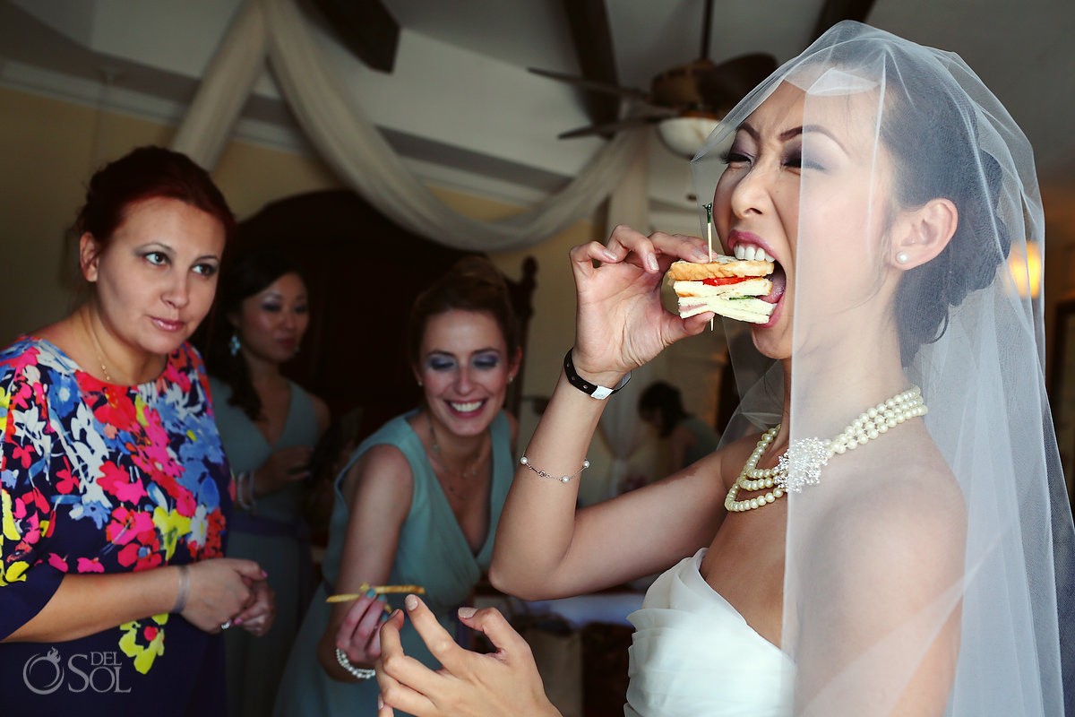 Bride eating a sandwich before the wedding
