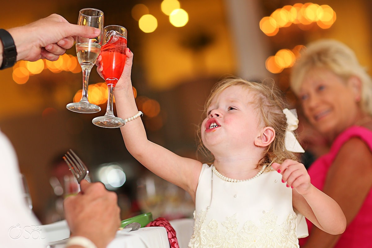 Small flowergirl toasting during a wedding reception