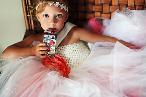 small flowergirl drinking hershey's milk at a wedding ceremony