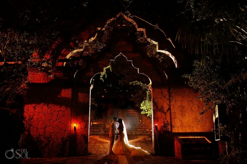 Architectural bride and groom night time wedding portrait inside the arch of Xcaret Park, Riviera Maya, Mexico