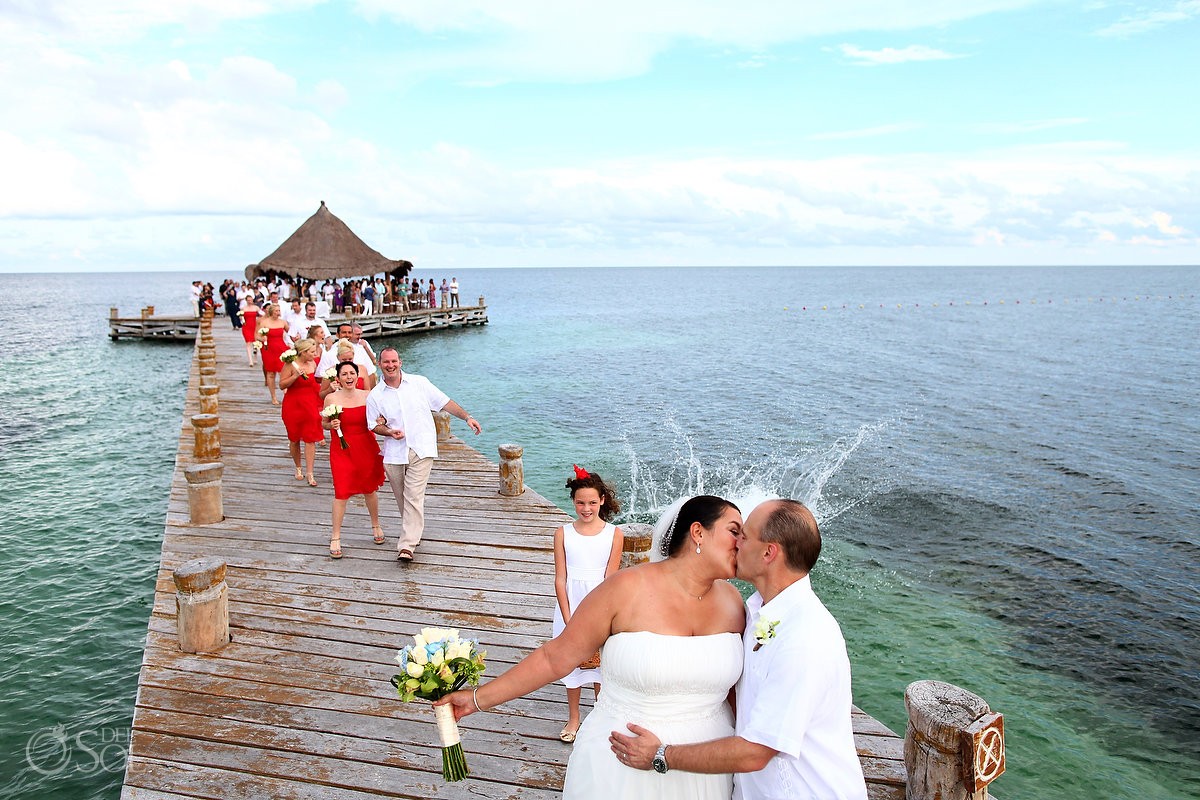 bride and groom iss guest jumps in water destination wedding photobomb