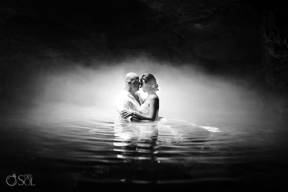 Photograph of bride and groom in a cenote cave during a mayan ceremony with epic light