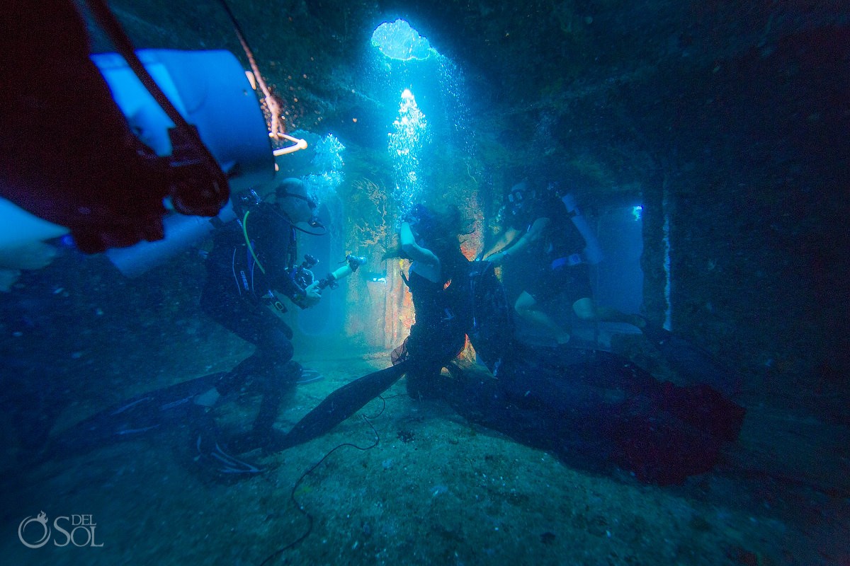 Safety divers and mermaid model for underwater photoshoot