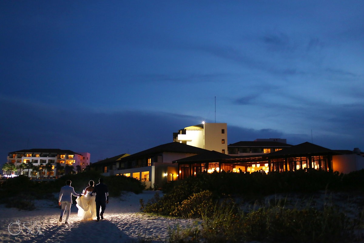 sunset /dusk light with bride and groom walking on the beach at Secrets Playa Mujeres, Cancun, Mexico