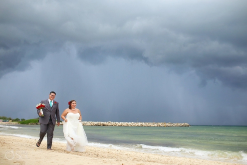 bride and groom walking on rainy beach at now jade hotel