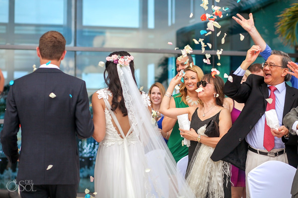 Guests throw red white blue color rose petals, wedding ceremony exit, Terrace, live Aqua Cancun, Mexico