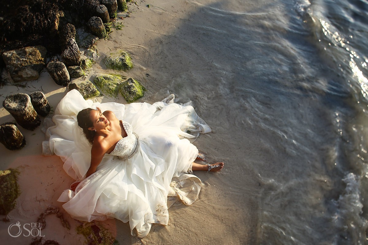 Beautiful bride lying waters edge, Sunrise wedding portrait trash the dress Eddy K Puerto Morellos pier, Mexico
