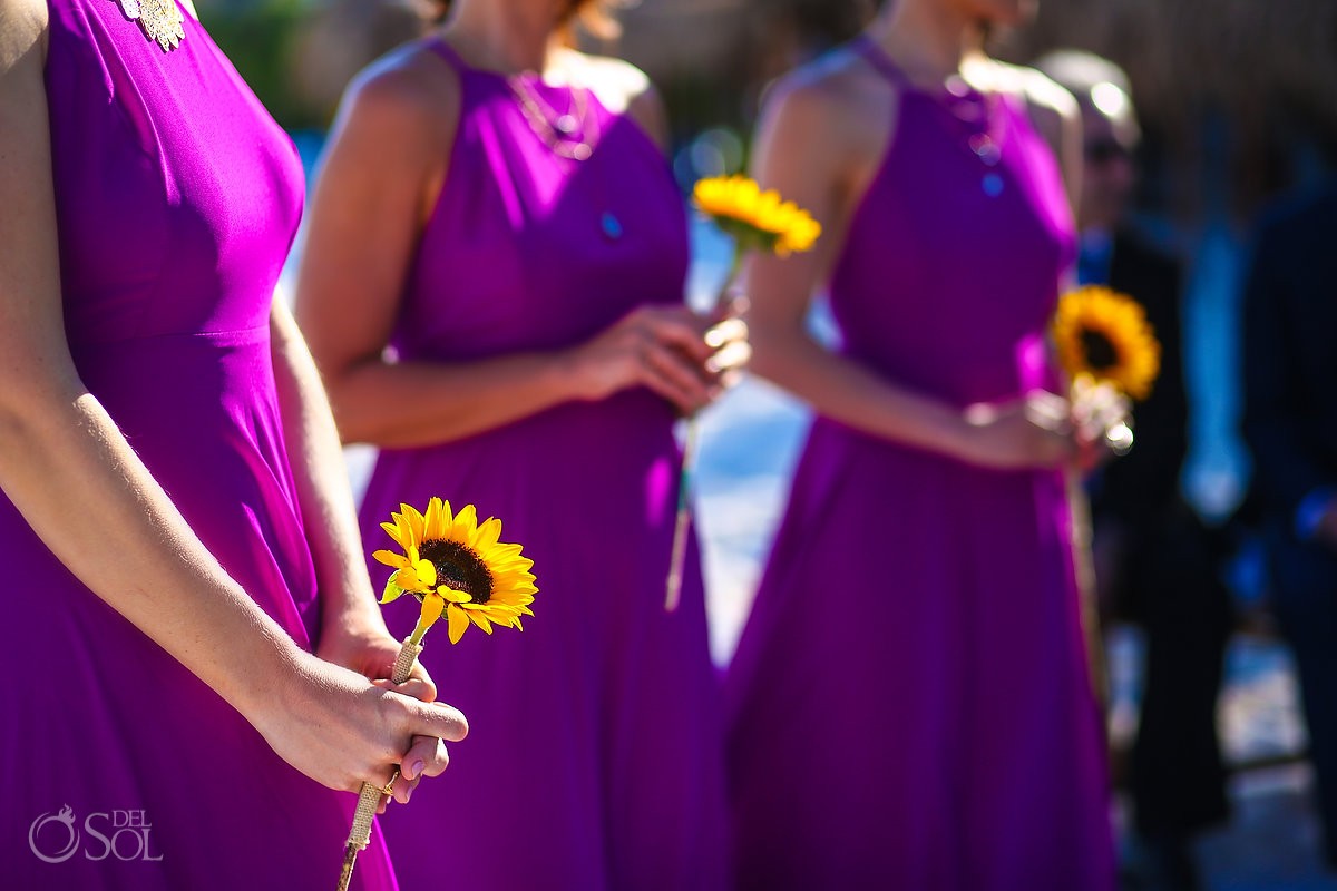 purple bridesmaids dresses with a single sunflower bouquet