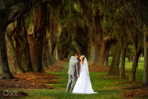 bride and groom kiss at avenue of the oaks st simons island wedding
