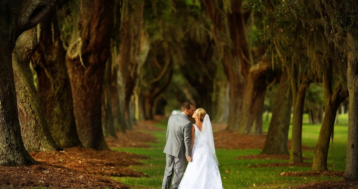 bride and groom kiss at avenue of the oaks st simons island wedding