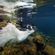 groom holding Eve of Milady Wedding dress underwater cenote photography Riviera Maya Mexico