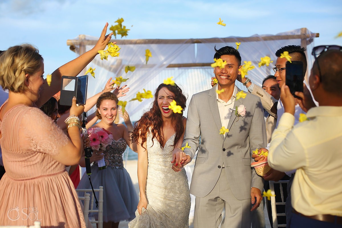 ceremony exit idea wedding guest throw bright yellow flowers confetti, just married, destination wedding Royalton Riviera Cancun, Mexico