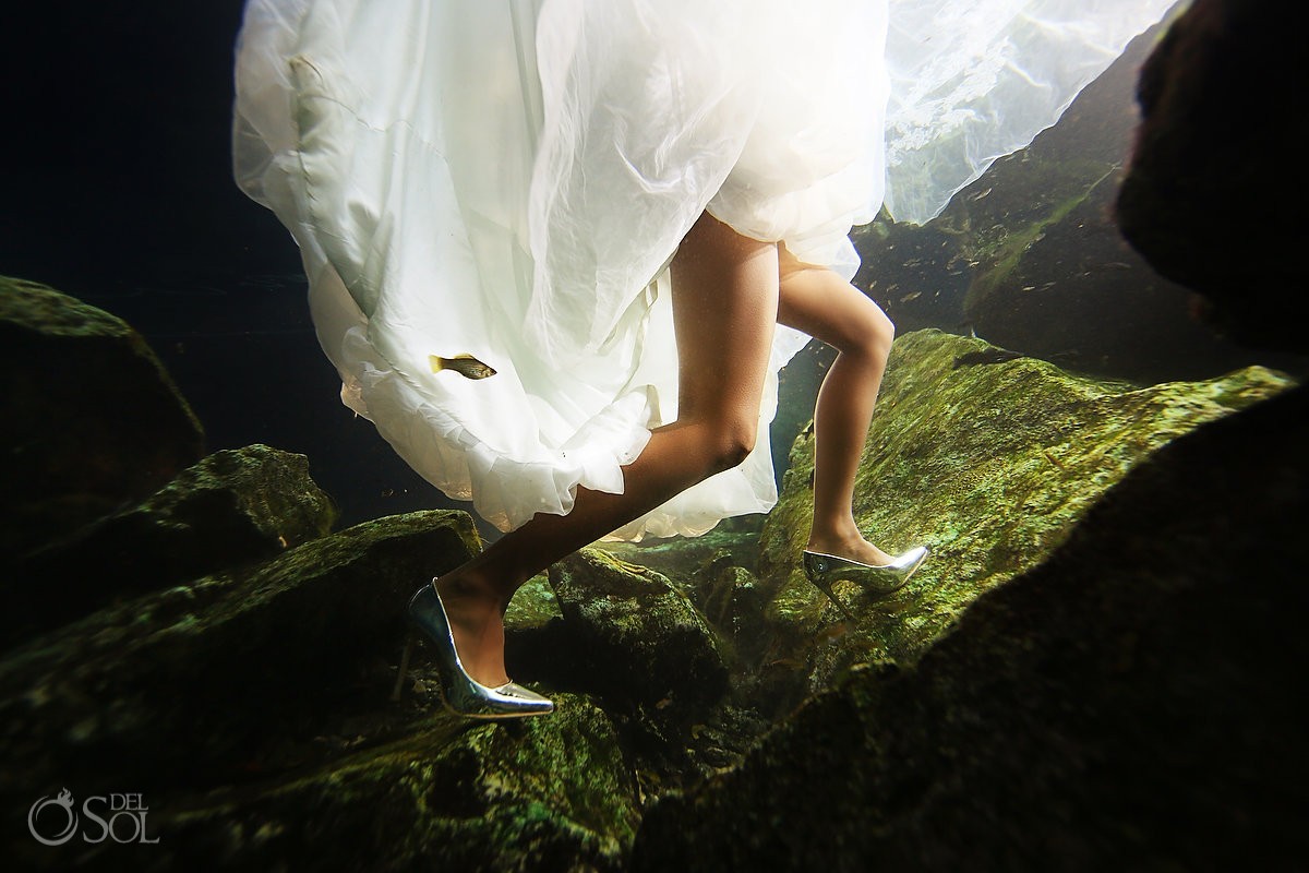 bride with fish following her walking underwater with high heels