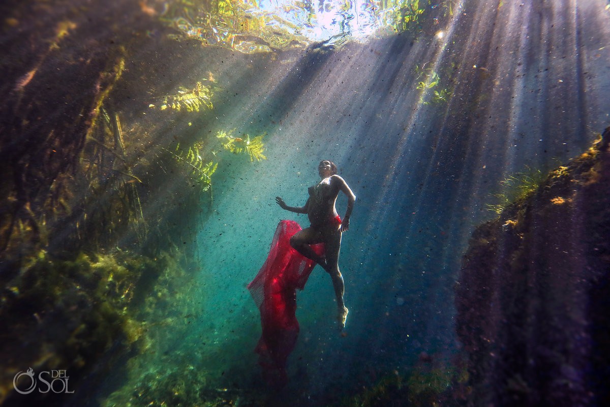 underwater maternity photo pregnant mother swimming through rays of light four elements water photoshoot