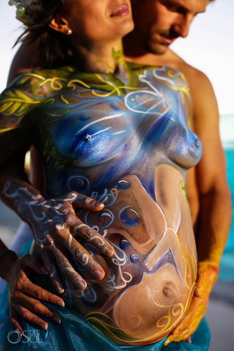 maternity pregnancy body paint belly and fathers hands representation of the four elements
