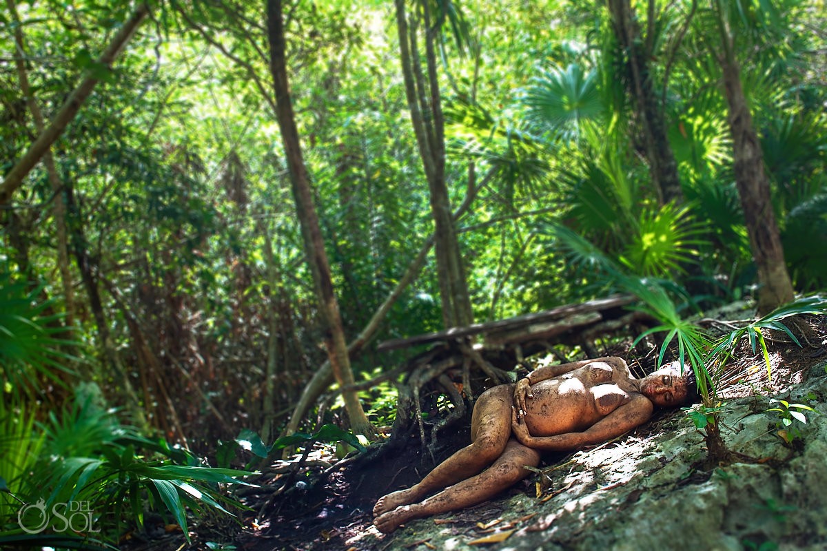 mother nature maternity photo shoot pregnant brother covered in earth lying in the jungle