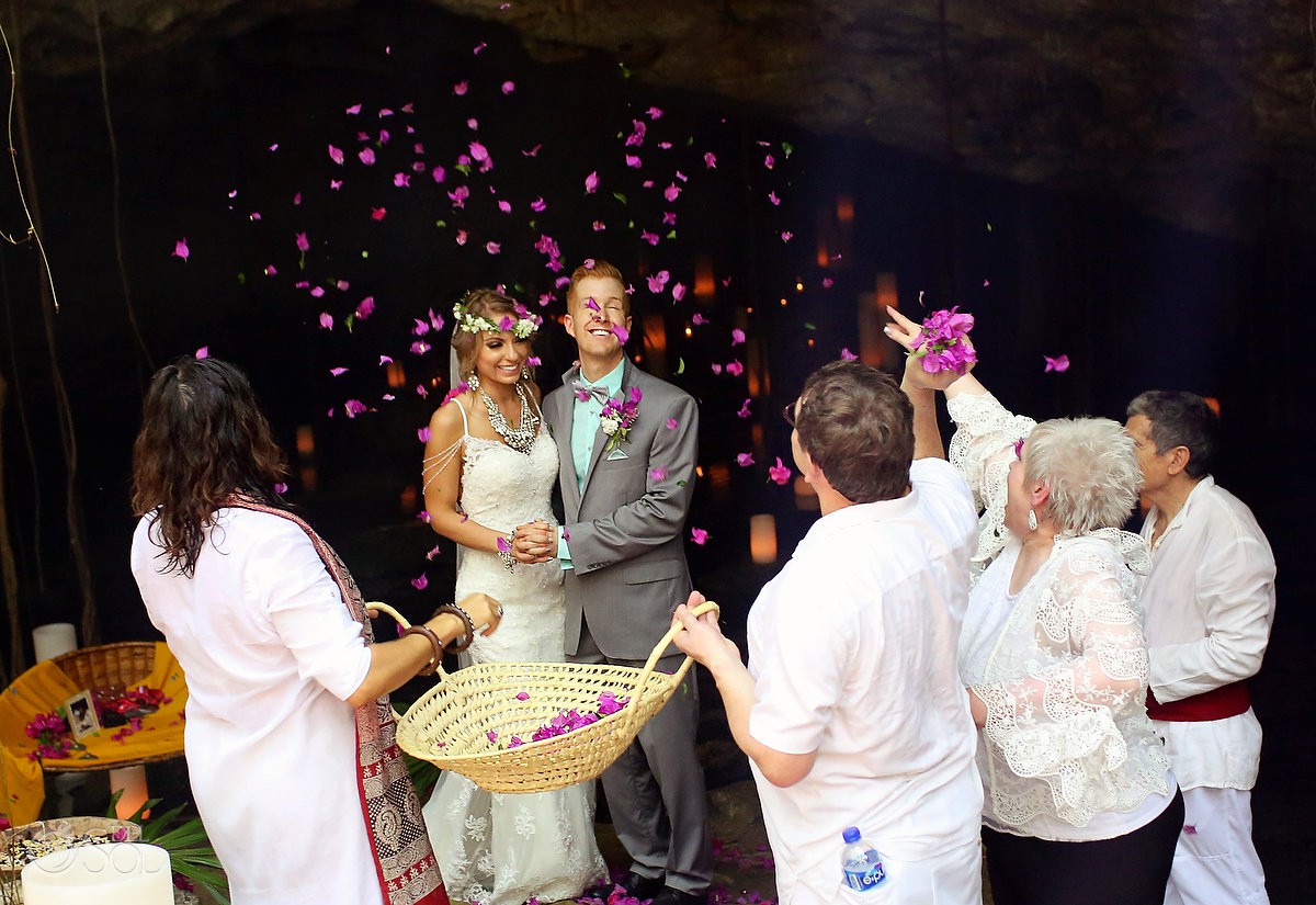 elopement celebration parents throwing pink flowers on bride and groom cenote Riviera Maya