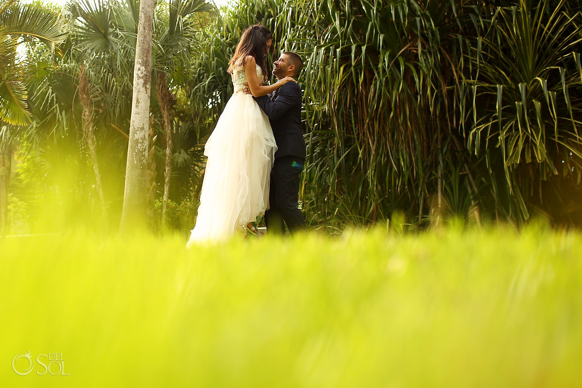 fun wedding photo groom lifts bride Mahekal gardens Playa del Carmen Mexico