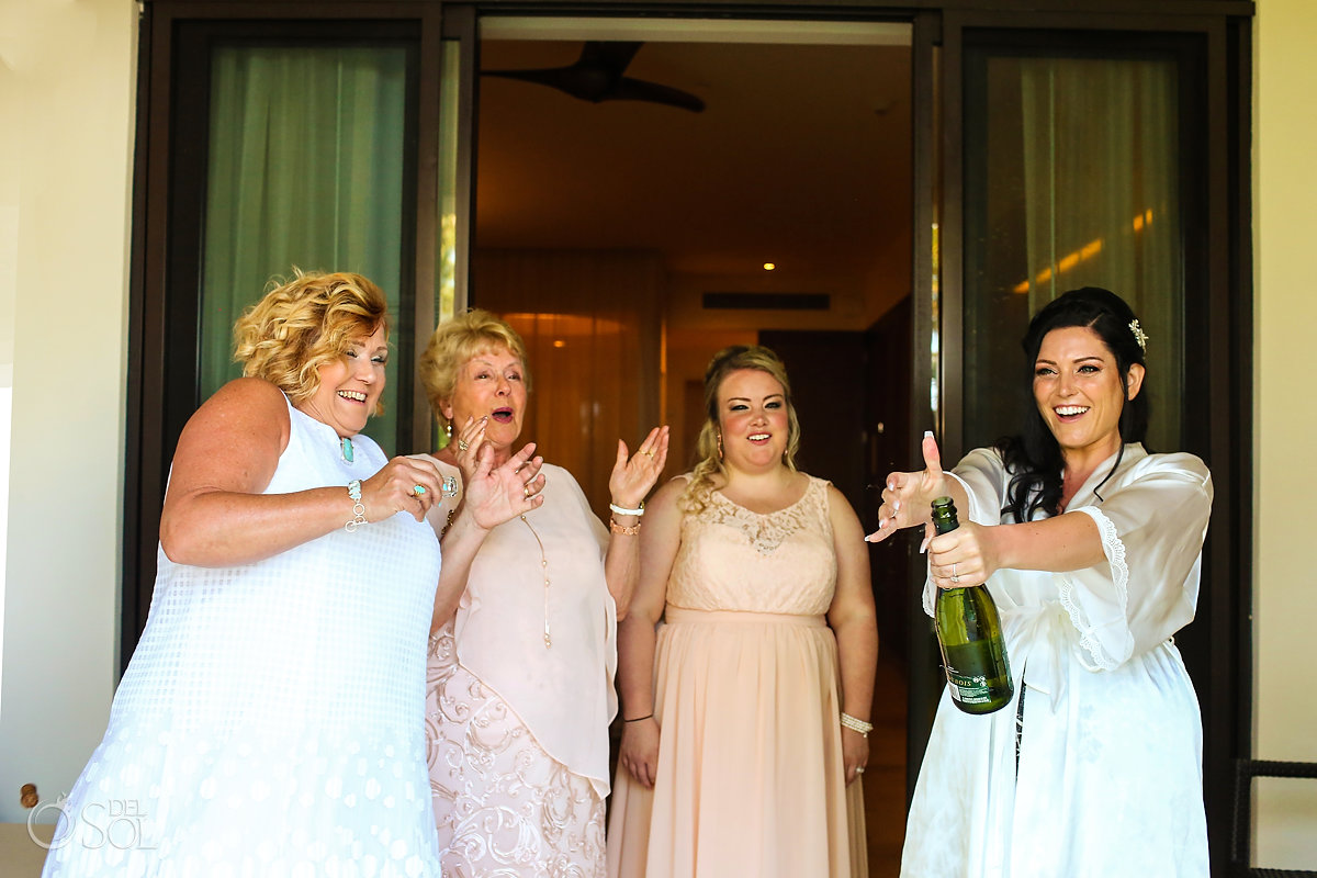 funny wedding photo bride opens champagne candid family portrait Secrets Akumal