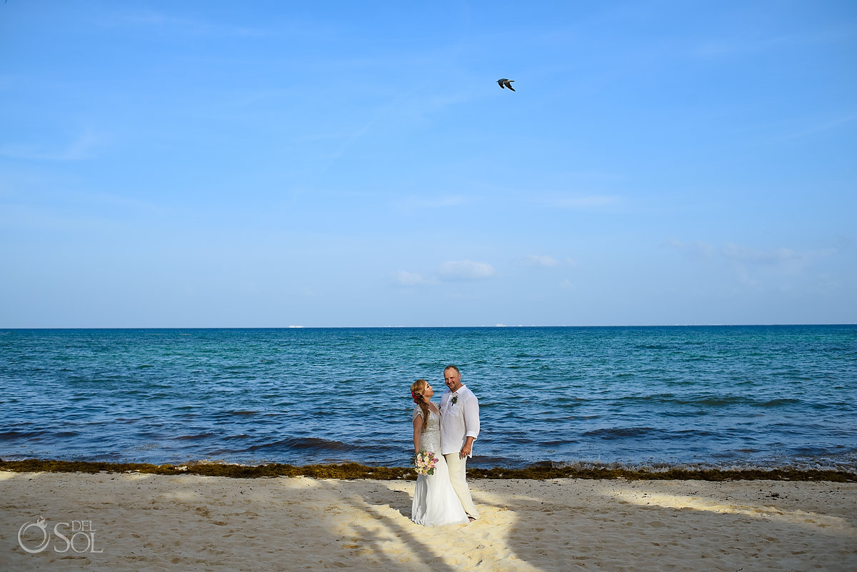beach wedding portrait bird flys over couple Mahekal Beach resort Playa del Carmen Mexico
