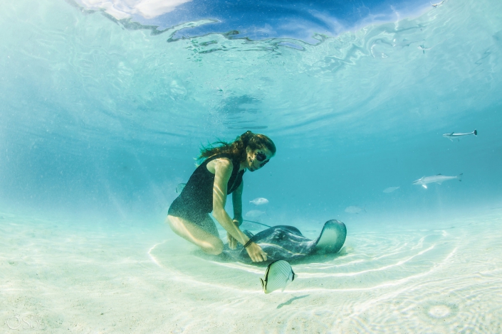 Catrina Makeup woman playing with stingray light reflections clear amazing water white sand Tahiti underwater photography