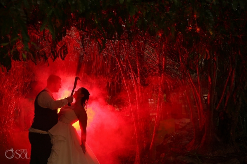 Maggie Sottero Trash the Dress halloween horror wedding photo groom holding machete over bride with red smoke