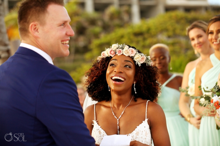 bride wearing flower crown laughs during wedding vows Playa UK Hotel Xcaret Mexico