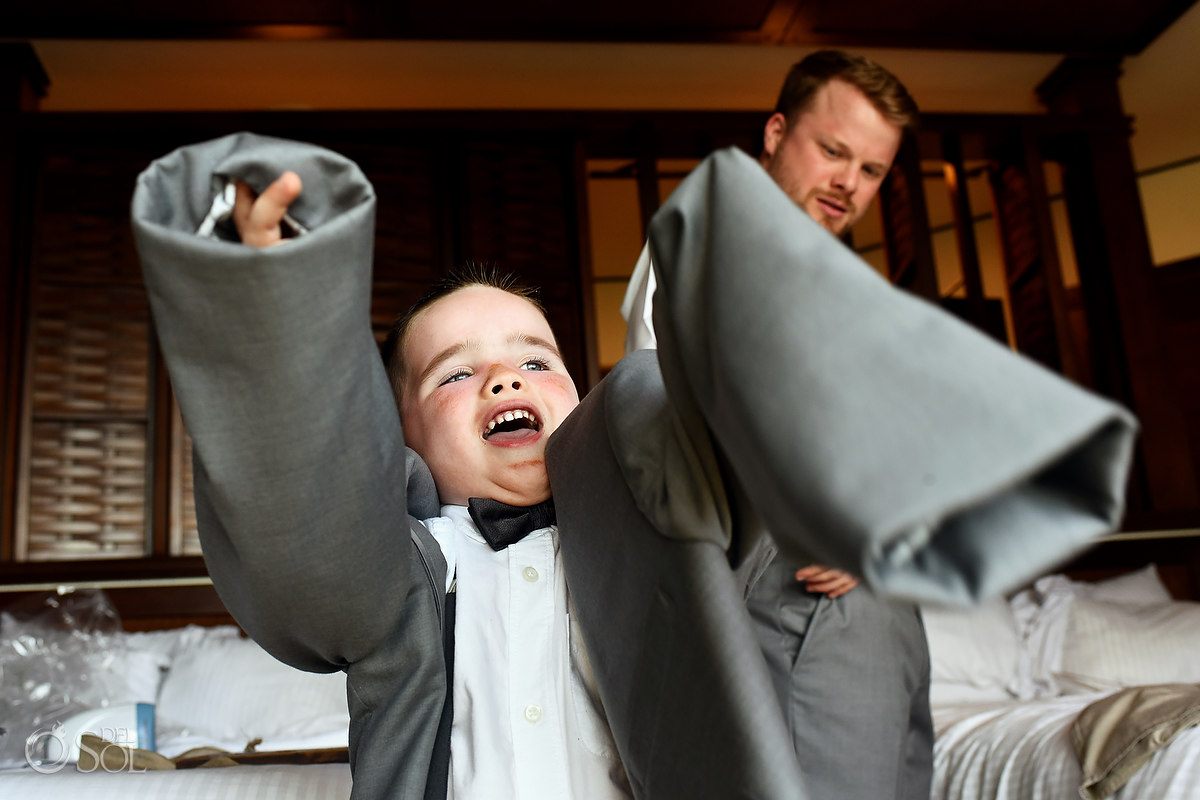 funny wedding photo ringbearer trying on suit jacket kids will be kids