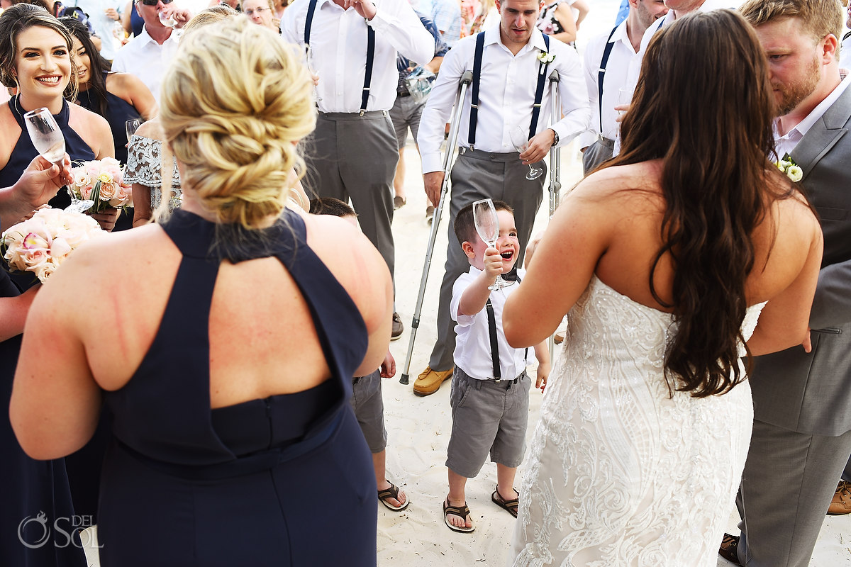 ringbearer gives champagne toast cheers to bride and groom