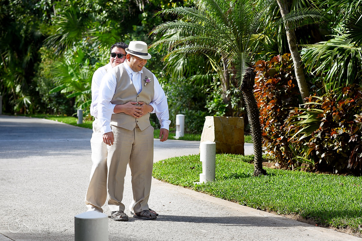 funny wedding photogroomsman hugs groom waiting for first look