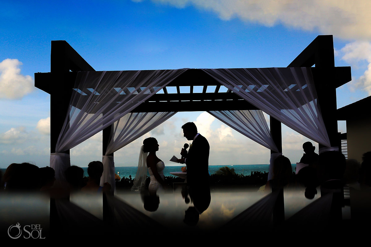 groom reading vows silhouette Secrets laya Mujeres Gazebo Cancun