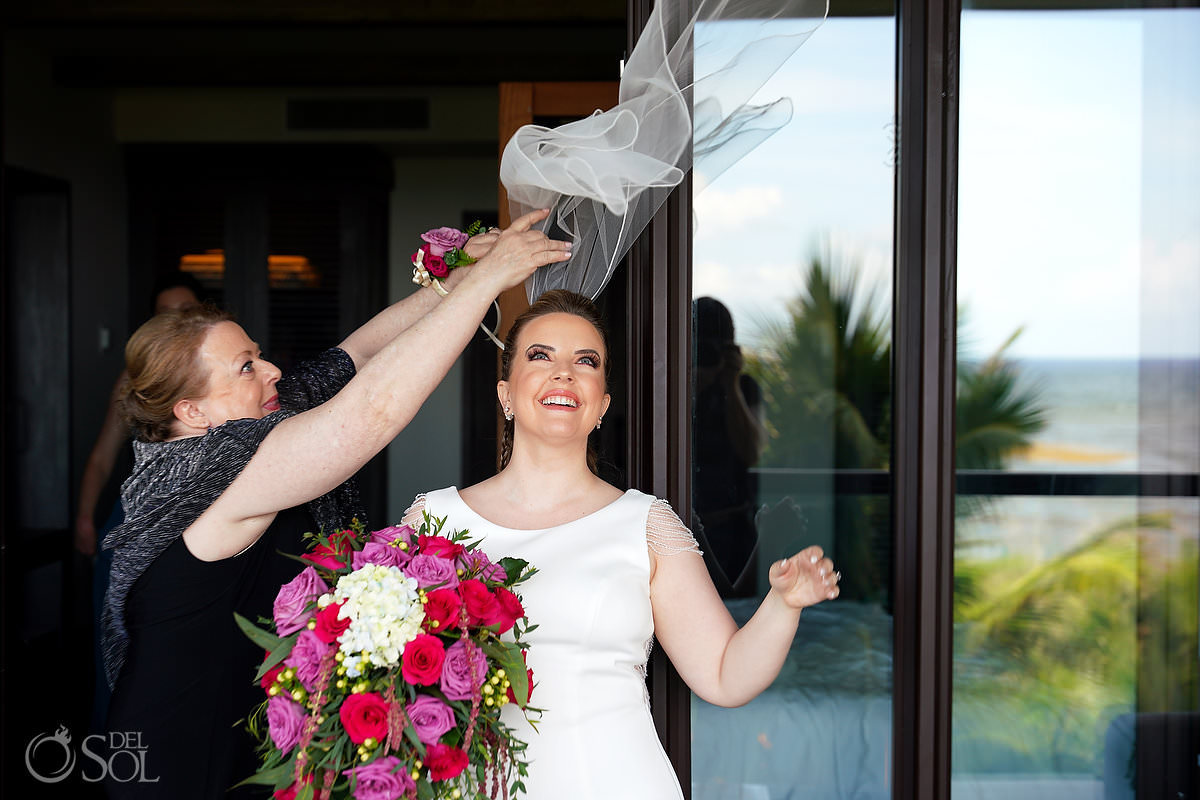 mom putting on brides wedding veil flying away in the wind