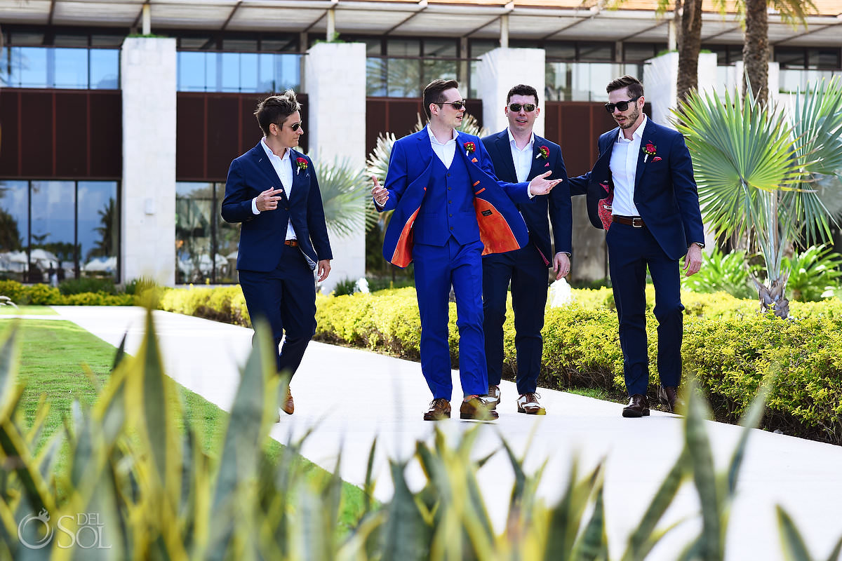 groom and groomsmen wearing navy and royal blue suits with bright orange and pink linings