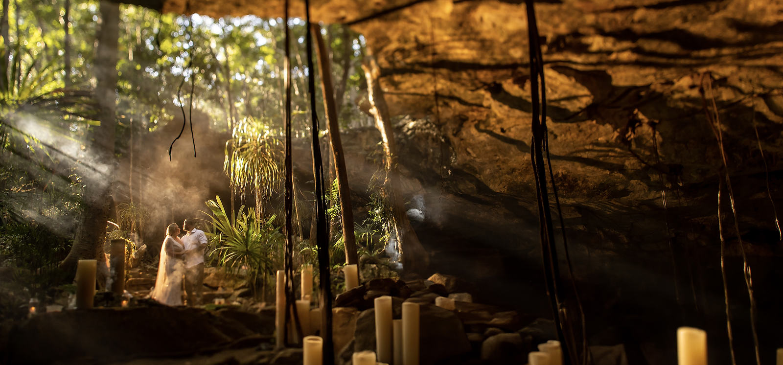 Bride and groom in a cenote with candles and beautiful lighting in Mexico for a micro wedding ceremony