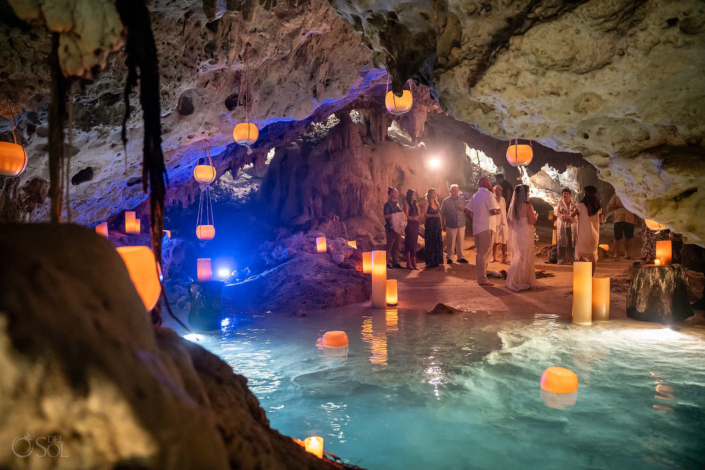 blue water with floating and hanging candles Romantic family cenote wedding