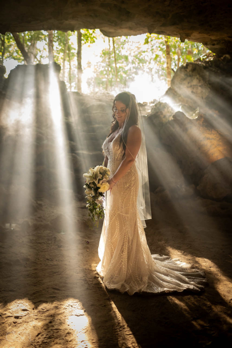 bride with floral bouquet in a cenote wedding