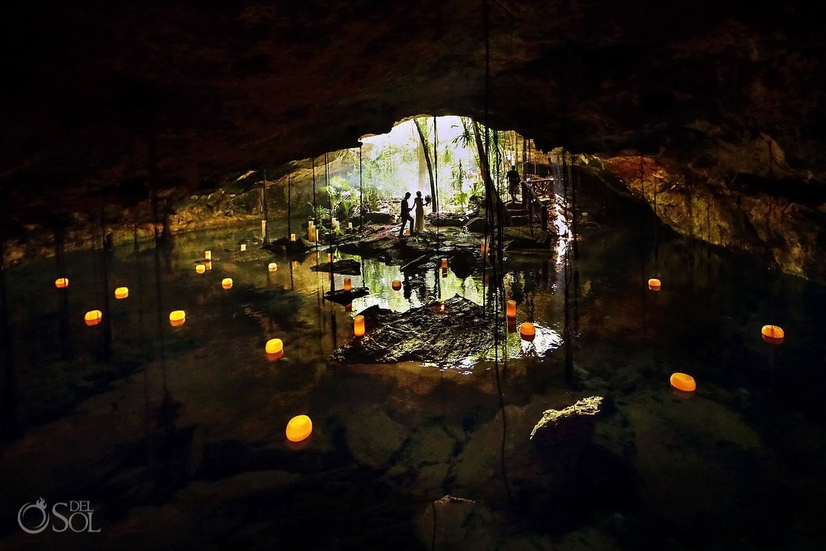 Cenote Weddings By Matt Adcock, micro ceremony bride and groom and Mayan shaman, with floating candle decoration with a reflection in the cenote waters