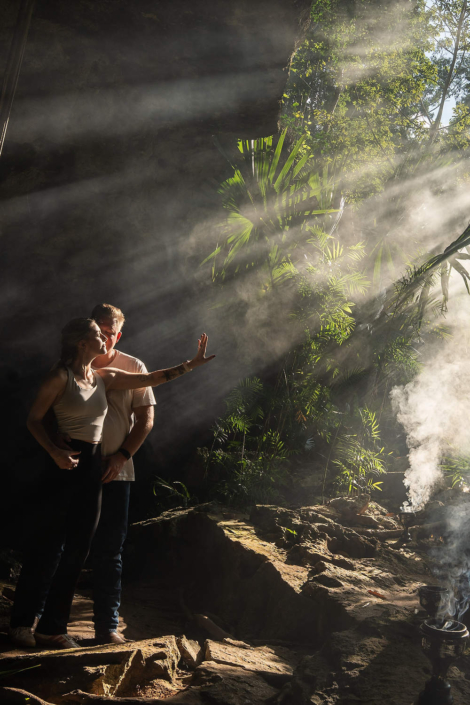Couple posing for professional engagement photos inside a natural cenote in the Riviera Maya, Mexico