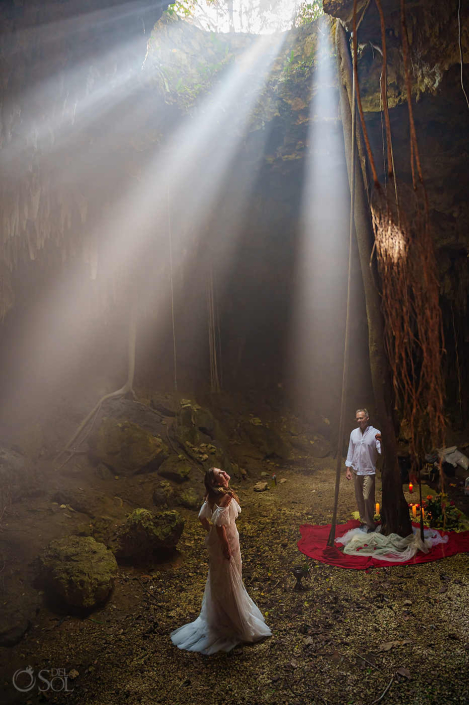 Beautiful couple portrait inside a cenote cave illuminated by natural light