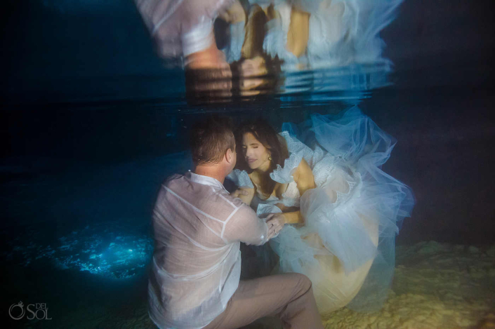 Underwater trash the dress session of a bride and groom inside a cenote