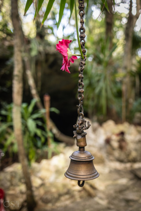 Ceremonial bell to represent being cancer free hanging beside the cenote during a spiritual vow renewal