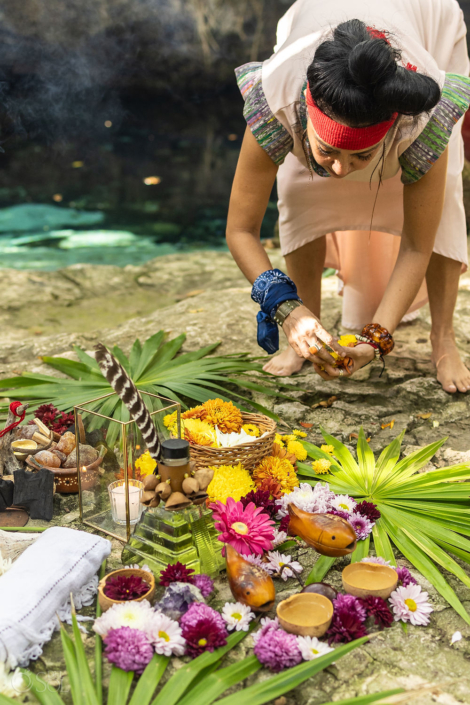 Preparing ceremonial offerings beside the cenote in Riviera Maya