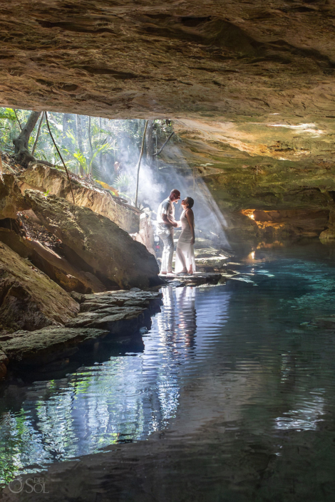 Couple during an intimate cenote vow renewal ceremony inside a crystal blue cave in Riviera Maya Mexico