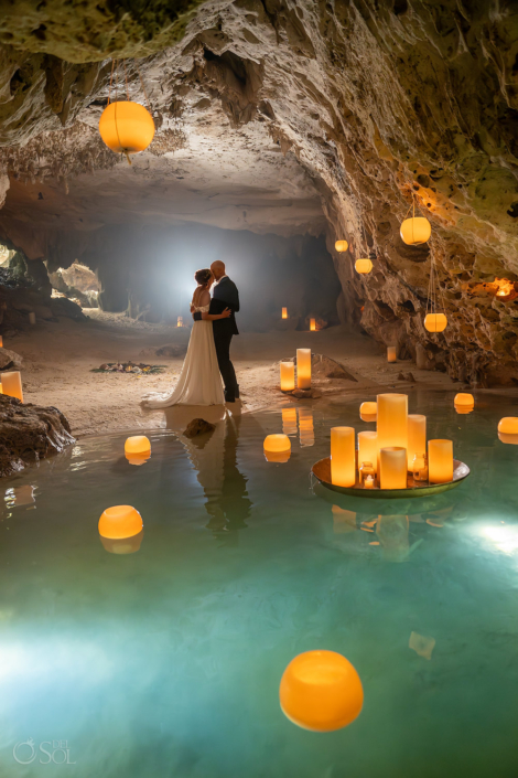 Romantic portrait surrounded by floating candles during a cenote wedding ceremony.